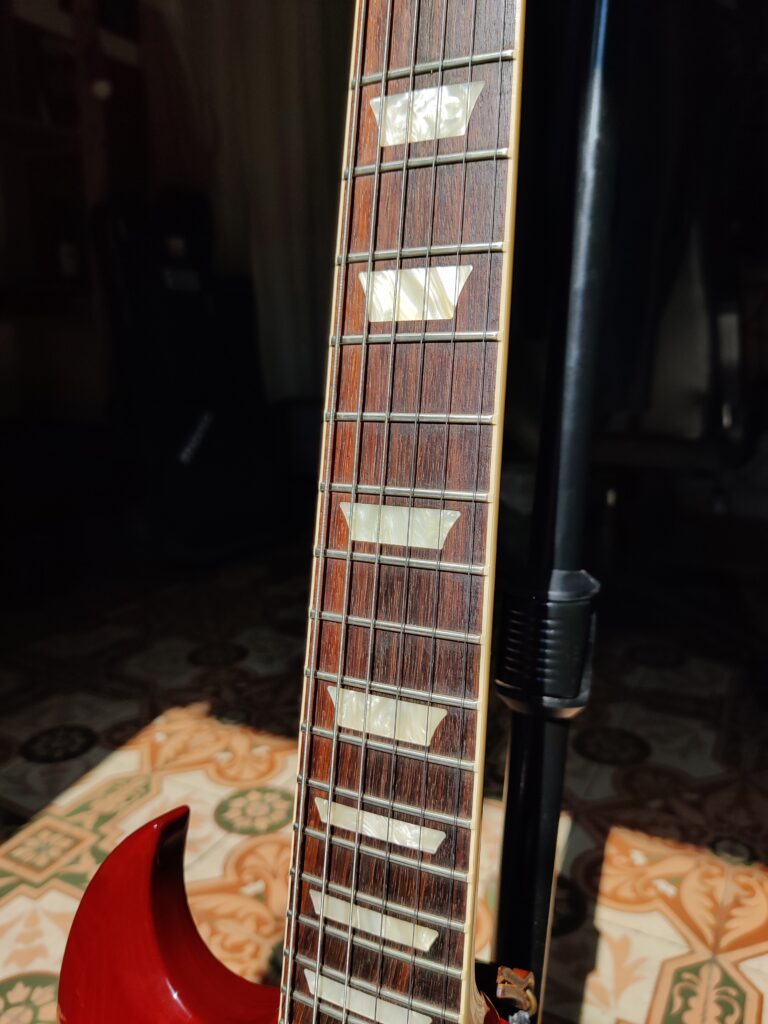 Mahogany neck with rosewood fretboard, binding, and acrylic trapezoid inlays